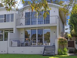 uma casa com grandes janelas e um alpendre em The Quarterdeck em Port Fairy