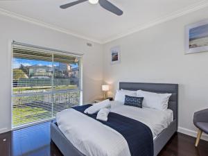 a bedroom with a large bed and a window at Driftwood House in Port Fairy
