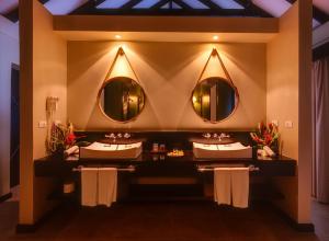 a bathroom with two sinks and two mirrors at Warwick Le Lagon Resort & Spa, Vanuatu in Port Vila