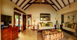 a living room with a couch and a tv at Warwick Le Lagon Resort & Spa, Vanuatu in Port Vila