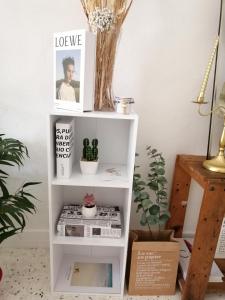 un estante de libros blanco en una habitación con plantas en little heritage home, en George Town