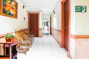 un couloir d'un hôpital avec des chaises et des tables dans l'établissement OYO 499 Le Pensione De San Jose, à Tagbilaran