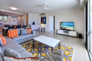 a living room with a couch and a tv at Hamilton Island Holiday Homes in Hamilton Island