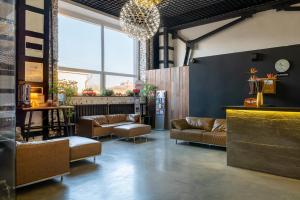 a lobby with brown leather couches and a large window at Astoria Hotel in Vladivostok