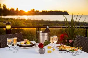 a table with a glass of wine and a plate of food at The Beach Club Resort — Bellstar Hotels & Resorts in Parksville