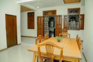 ウェリガマにあるColonial Houseの木製のテーブルと椅子のあるダイニングルーム