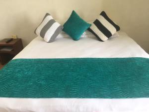 uma cama com quatro almofadas em cima em Moorings Hotel em Port Vila