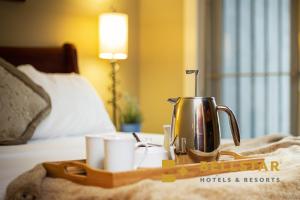 een dienblad met een koffiepot en kopjes op een bed bij Solara Resort by Bellstar Hotels in Canmore