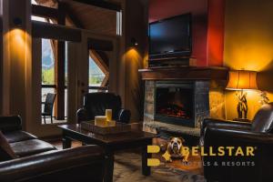 a living room with a fireplace and a tv at Solara Resort by Bellstar Hotels in Canmore