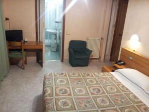 sypialnia z łóżkiem, biurkiem i krzesłem w obiekcie Hotel Acapulco w Mediolanie
