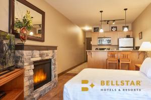 une chambre d'hôtel avec une cheminée et une cuisine dans l'établissement Palliser Lodge — Bellstar Hotels & Resorts, à Golden