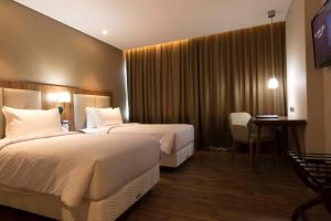 Postel nebo postele na pokoji v ubytování Avenzel Hotel & Convention Cibubur