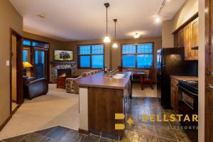 eine Küche und ein Wohnzimmer mit einem Sofa und einem Tisch in der Unterkunft Glacier Mountaineer Lodge in Golden