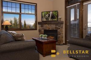 a living room with two couches and a fireplace at Glacier & Mountaineer Lodge in Golden