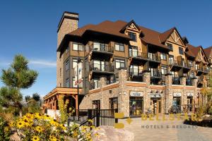 a large brown building with a brown roof at Glacier Mountaineer Lodge in Golden