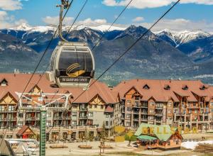 a gondola ride in front of a resort with mountains at Glacier & Mountaineer Lodge in Golden
