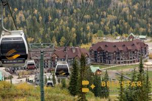 two gondolas in a ski lift in front of a resort at Glacier & Mountaineer Lodge in Golden +21 photos