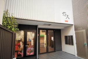 uma entrada para uma loja com uma porta de vidro em Residence Saku em Osaka