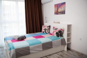 a bedroom with a bed with a colorful blanket at Business sky Loft in Sofia