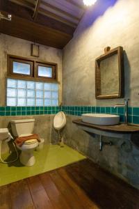 a bathroom with a toilet and a sink and a mirror at Baan Suan Ramita Resort in Chanthaburi