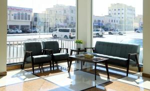 een kamer met stoelen, een salontafel en een raam bij Al Nile (3) Furnished Flats in Salalah