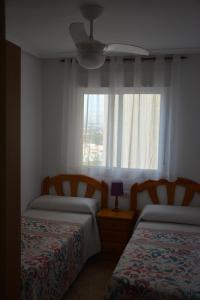 a bedroom with two beds and a window at Arenales Beach in Arenales del Sol