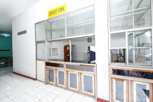 a restaurant with a counter with a sign on the wall at SPOT ON 2289 Hotel Saudara in Tegal