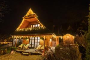 une maison avec des lumières de Noël allumées la nuit dans l'établissement Dziko Hanka, à Kościelisko