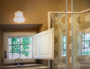 a bathroom with a shower and a sink and two windows at Villa Le Fontanelle in Florence