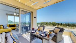 Liberty & Freedom Luxury Villas في بلاتانياس: غرفة معيشة مع طاولة وكراسي