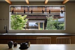 eine Küche mit einem großen Fenster über einem Waschbecken in der Unterkunft modern ryokan kishi-ke in Kamakura