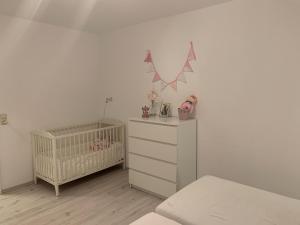 a nursery with a crib and a dresser and a crib at Haus Fasanenweg in Mutlangen