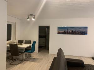une salle à manger avec une table et des chaises et un tableau au mur dans l'établissement Haus Fasanenweg, à Mutlangen