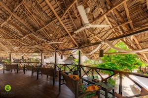 a dining area with chairs and a ceiling at Makofi Guest House in Nungwi