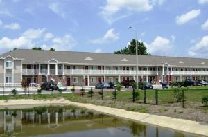 a large building with a pond in front of it at Affordable Suites Jacksonville in Jacksonville