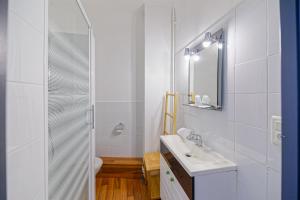 une salle de bain blanche avec un lavabo et une douche dans l'établissement Hotel Cote Basque, à Bayonne
