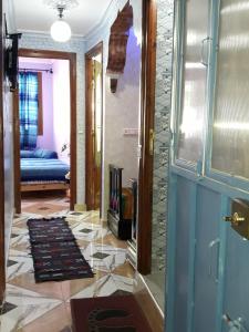 a hallway with a door and a tile floor at Maison Bahija in Chefchaouen