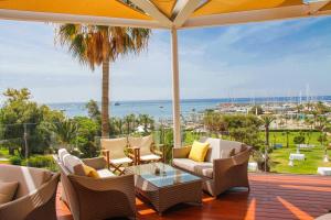 a patio with chairs and a table and a view of the ocean at St Raphael Resort in Limassol