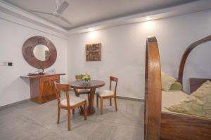 Habitación con mesa, cama y espejo. en Elixir Hills Suites Resort and Spa en Munnar