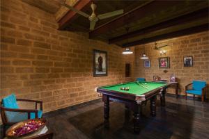 a pool table in a room with a brick wall at WelcomHeritage Mohangarh Fort in Jaisalmer