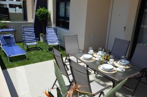 una mesa y sillas con platos y platos. en Higuericas Beach Apartment, en Pilar de la Horadada