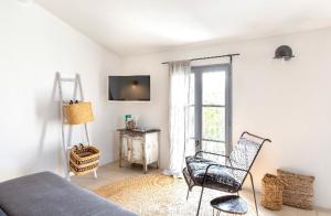 リル・シュル・ラ・ソルギュにあるSuite Sur La Sorgueのベッドルーム1室(ベッド1台、椅子、窓付)