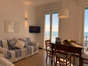 a living room with a couch and a table at Lo Scoglio by Holiday World in Cavi di Lavagna