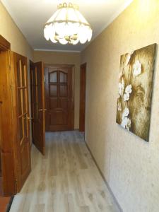 an empty room with a chandelier and a hallway at Apartment on 700-letiya Kobrina 4 in Kobryn