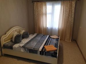 a bedroom with a large bed with a window at Apartment on 700-letiya Kobrina 4 in Kobryn