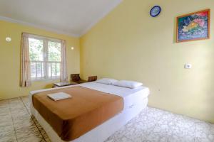 Un pat sau paturi într-o cameră la Hotel Kayu Manis