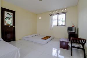 Un pat sau paturi într-o cameră la Hotel Kayu Manis