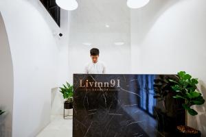 a young man standing behind a desk in a room at Livinn91 Hotel in Bangkok