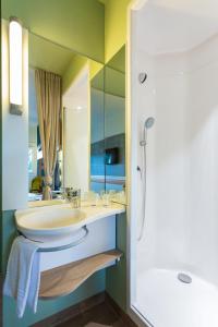 La salle de bains est pourvue d'un lavabo et d'un miroir. dans l'établissement ibis budget Berck Sur Mer, à Berck-sur-Mer