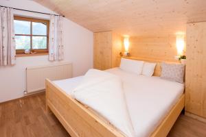 a bedroom with a large white bed in a room at Apart Falkneralm in Längenfeld